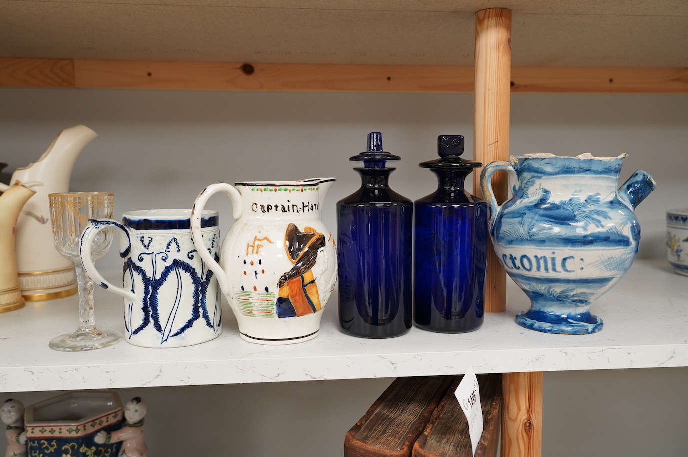 An 18th century pearlware mug, an 18th century Italian maiolica wet drug jar, a faceted wine glass, a commemorative jug and a pair of Bristol blue glass decanters and stoppers, tallest 19cm. Condition - varies